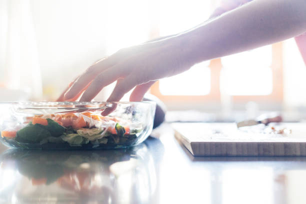 istock Woman preparing salad in the kitchen with her hands 1248168874