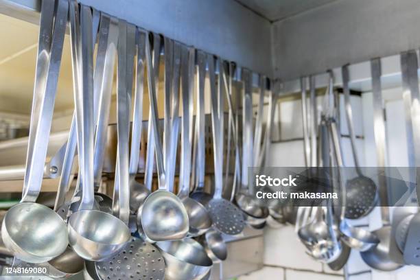 Close Up View Of Many Soup Ladles Hanging From A Wall Rack In A Restaurant Kitchen Stock Photo - Download Image Now
