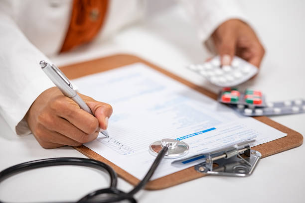 Doctor writing and checking medical prescription Closeup of woman hands writing medicine inventory. Close up hands of female doctor writing the medicines to be taken on the preoperative model sheet. Pharmacist checking inventory at hospital pharmacy. dose stock pictures, royalty-free photos & images