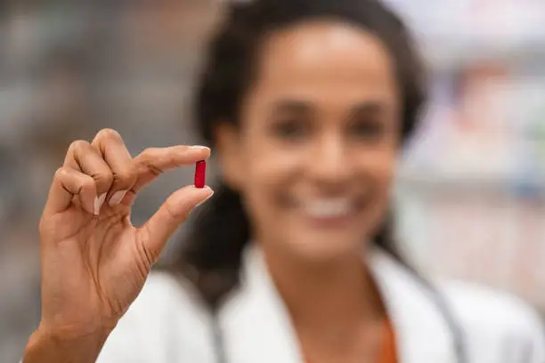 Photo of Pharmacist showing red pill