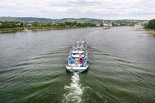 A large tanker ship sailing in Germany on the Rhine River. Transportation of oil, gas and gasoline, view from above.