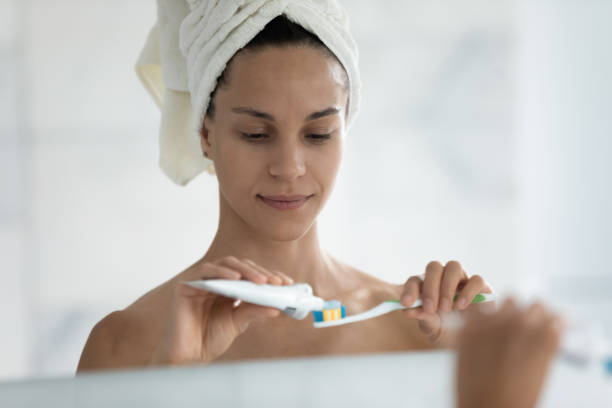 istock Head shot mirror reflection beautiful woman applying toothpaste on toothbrush 1248172036