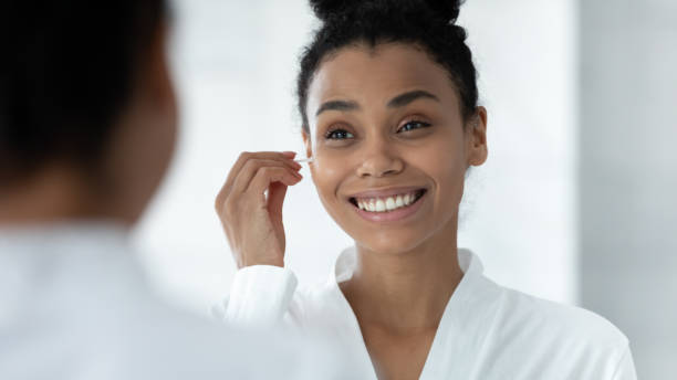 istock Mirror reflection African American woman cleaning ears, using cotton bud 1248172088
