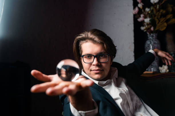 młody człowiek trzyma w ręku przezroczystą kryształową szklaną kulę - transparent crystal crystal ball human hand zdjęcia i obrazy z banku zdjęć