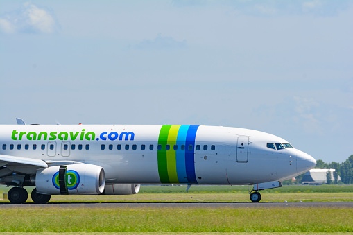 Boeing 737 of Transavia airlines landing at Schiphol airport during a beautiful springtime day. Transavia is aa Dutch low-cost airline and a subsidiary of KLM, part of the Air France–KLM group