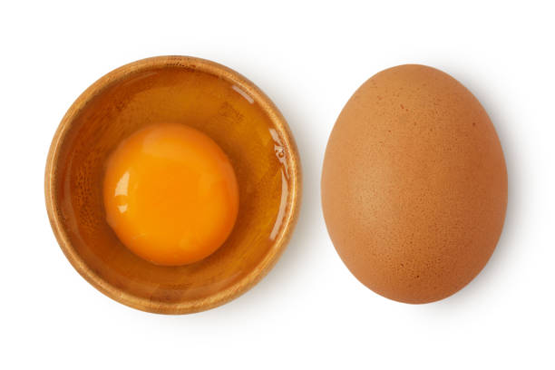 istock Egg in wooden bowl and egg with shell on white background 1248174447