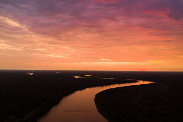 отражение заката над рекой куяба, пантанал, бразилия - dramatic sky horizon over water sunlight sunset стоковые фото и изображения