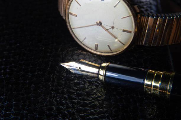 istock Fountain pen and antique watch in underexposed light 1248176224