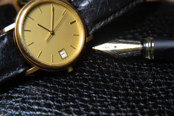 istock Fountain pen and antique watch in underexposed light 1248176350
