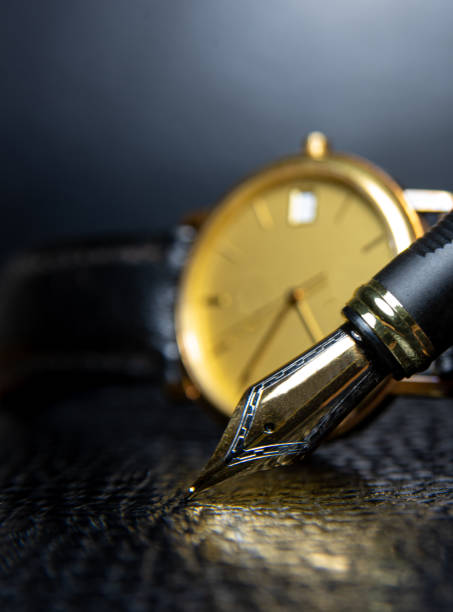 Fountain pen and antique watch in underexposed light