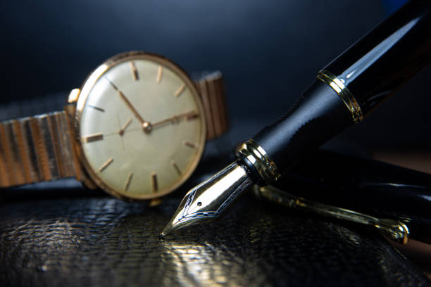 istock Fountain pen and antique watch in underexposed light 1248176819