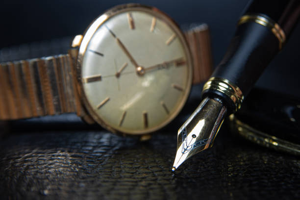 istock Fountain pen and antique watch in underexposed light 1248177032