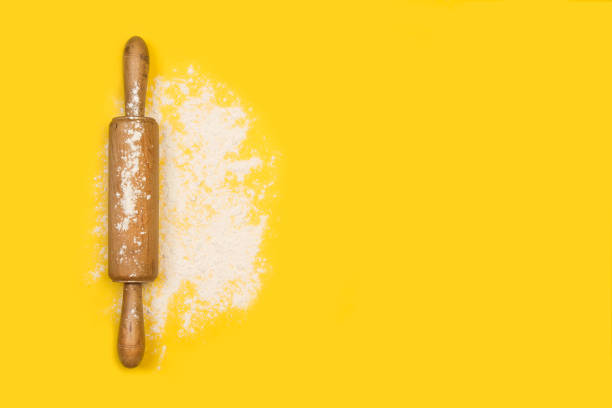 istock Rolling pin with flour on a yellow background 1248177825