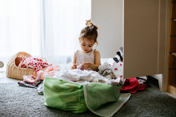 istock Little gilr reorganizing her wardrobe in her bedroom 1248179093