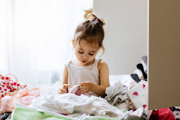 istock Little gilr reorganizing her wardrobe in her bedroom 1248180573