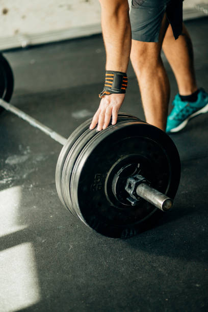 istock Handsome weightlifter preparing for training with barbell 1248180987
