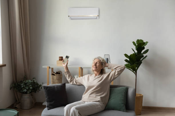 istock Senior woman breathe fresh air using AC at home 1248182124