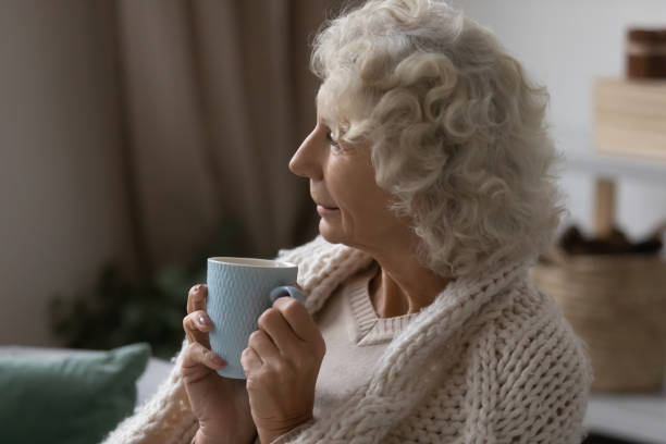 istock Elderly 50s woman relax on couch drinking tea 1248182176