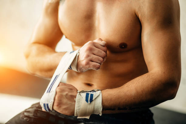 istock man getting prepared for the training, wrapping her hands with bandage tape 1248183489
