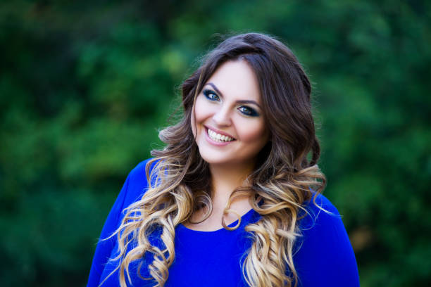 Happy plus size fashion model in blue dress outdoors, fat woman with beauty makeup and hairstyle Happy plus size fashion model in blue dress outdoors, fat woman with beauty makeup and hairstyle, body positive concept plus size woman fashion laughing stock pictures, royalty-free photos & images