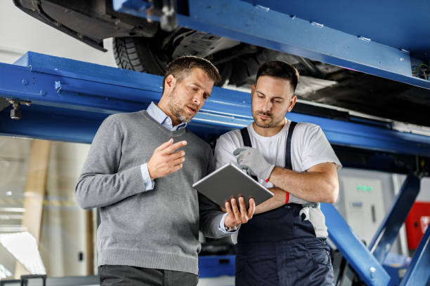 istock Auto mechanic and his manager using touchpad in a repair shop. 1248188995