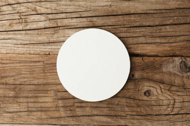 Beer coaster mockup on wooden background Beer coaster mockup on wooden background. coaster mockup stock pictures, royalty-free photos & images