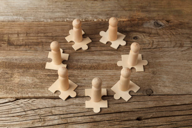 istock Wooden figures on puzzles. People analytics and optimization, team building. Group connection in business 1248189955
