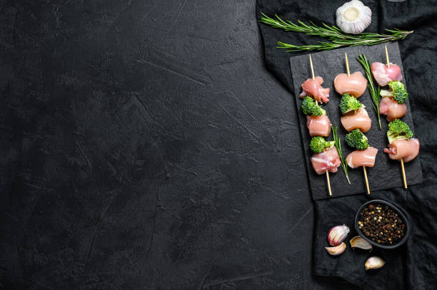 istock Raw chicken shish kebab with broccoli,  Barbecue. Black background. Top view. Space for text 1248197020
