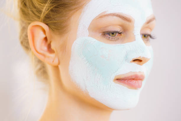 istock Girl with white green mud mask on face 1248198085