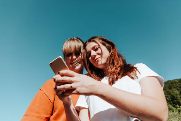 istock Young Women Reading Messages On Mobile Phone 1248198547