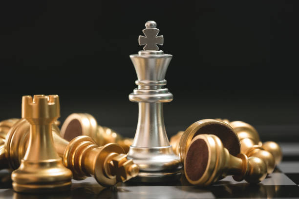 человеческая рука движущихся темный король шахматы кусок за столом - intelligence set armed forces competitive sport стоковые фото и изображения