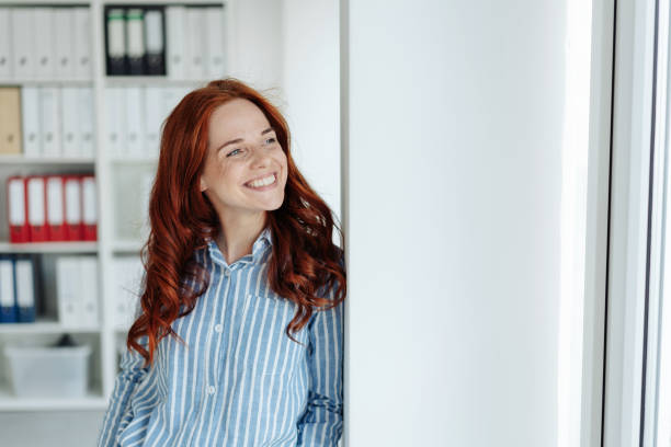 istock Young smiling red-haired woman in office 1248202154