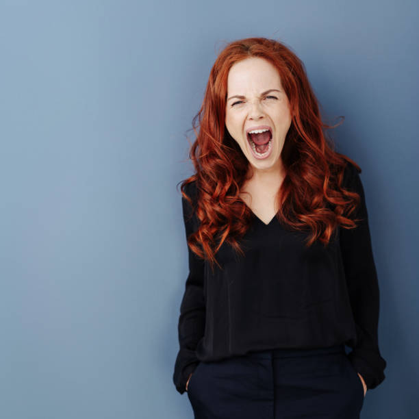 istock Angry young woman screaming with rage 1248202175
