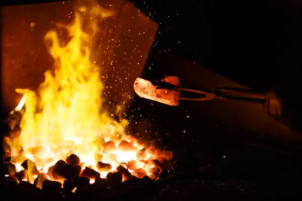 Forging the molten metal, making of an axe, traditional smithy