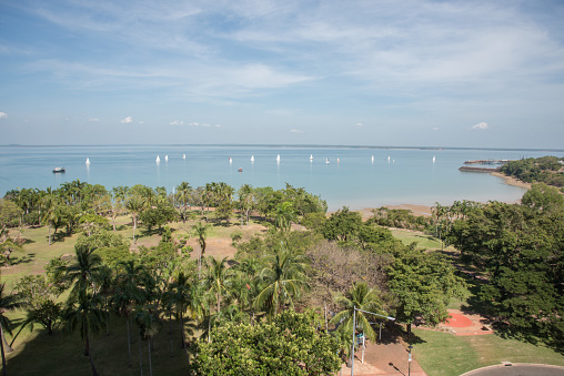 Darwin, NT, Australia-May 27,2018: View over Bicentennial Park with a large group of sailboats sailing in the Timor Sea harbor and military ship marina in Darwin in the NT of Australia