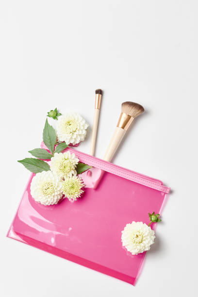 istock makeup concept. a pink cosmetic bag and makeup brushes. flat lay, vertical frame 1248209275