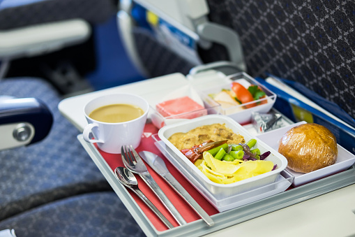 Tray of food on the airplane in the cabin economy class.