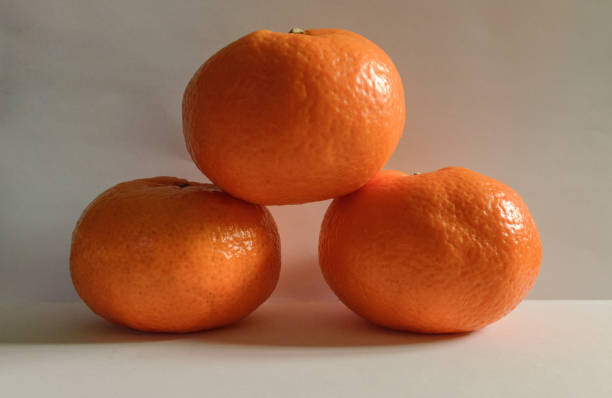 istock Dark Three Tangerines Podium On White Background 1248212366