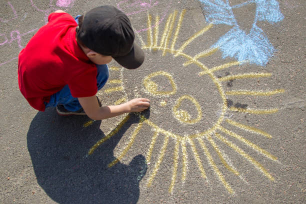 chłopiec rysuje kredą na chodniku słońce - little boys only playing preschooler child zdjęcia i obrazy z banku zdjęć