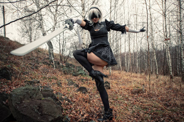 cosplay hermosa mujer en el bosque con vestido negro y con la espada - cosplay de anime fotografías e imágenes de stock