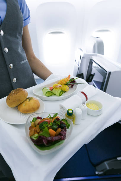 istock flight attendant serving meal in an airplane 1248213595
