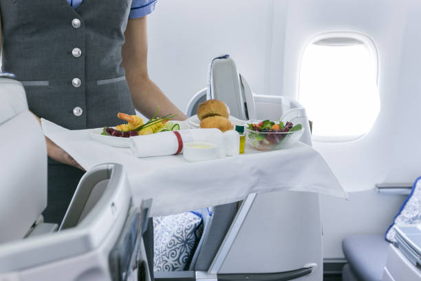 istock flight attendant serving meal in an airplane 1248213600