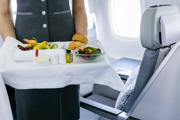 istock flight attendant serving meal in an airplane 1248213606