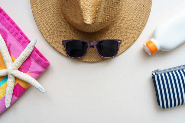istock A sun hat, sunglasses, sunscreen, and a colorful towel on a white background 1248216609