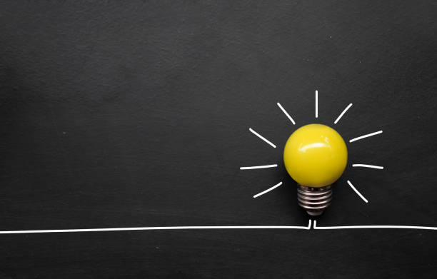 istock creativity inspiration, ideas concepts. light bulb on blackboard background. top view 1248225834