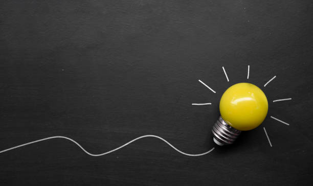 istock creativity inspiration, ideas concepts. light bulb on blackboard background. top view 1248225839