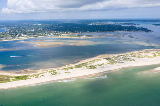 The cold waters of the Atlantic Ocean wash onto the scenic beaches of Cape Cod, Massachusetts. This sandy New England peninsula is a popular summer vacation area due to its natural beauty.