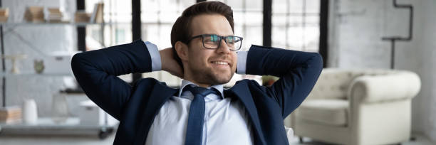 Panoramic view of young boss dreaming at workplace