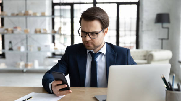 istock Serious male employer use gadgets at workplace 1248226381