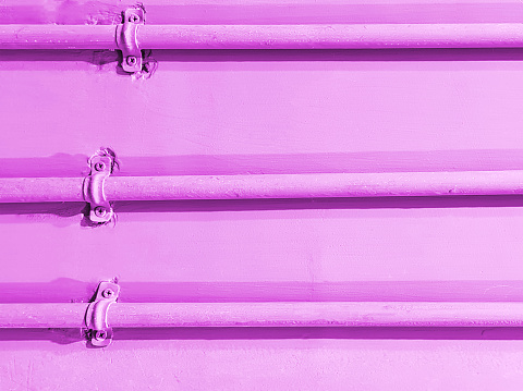 Full Frame Background of Three Pipes with Clamps on Pink Wall